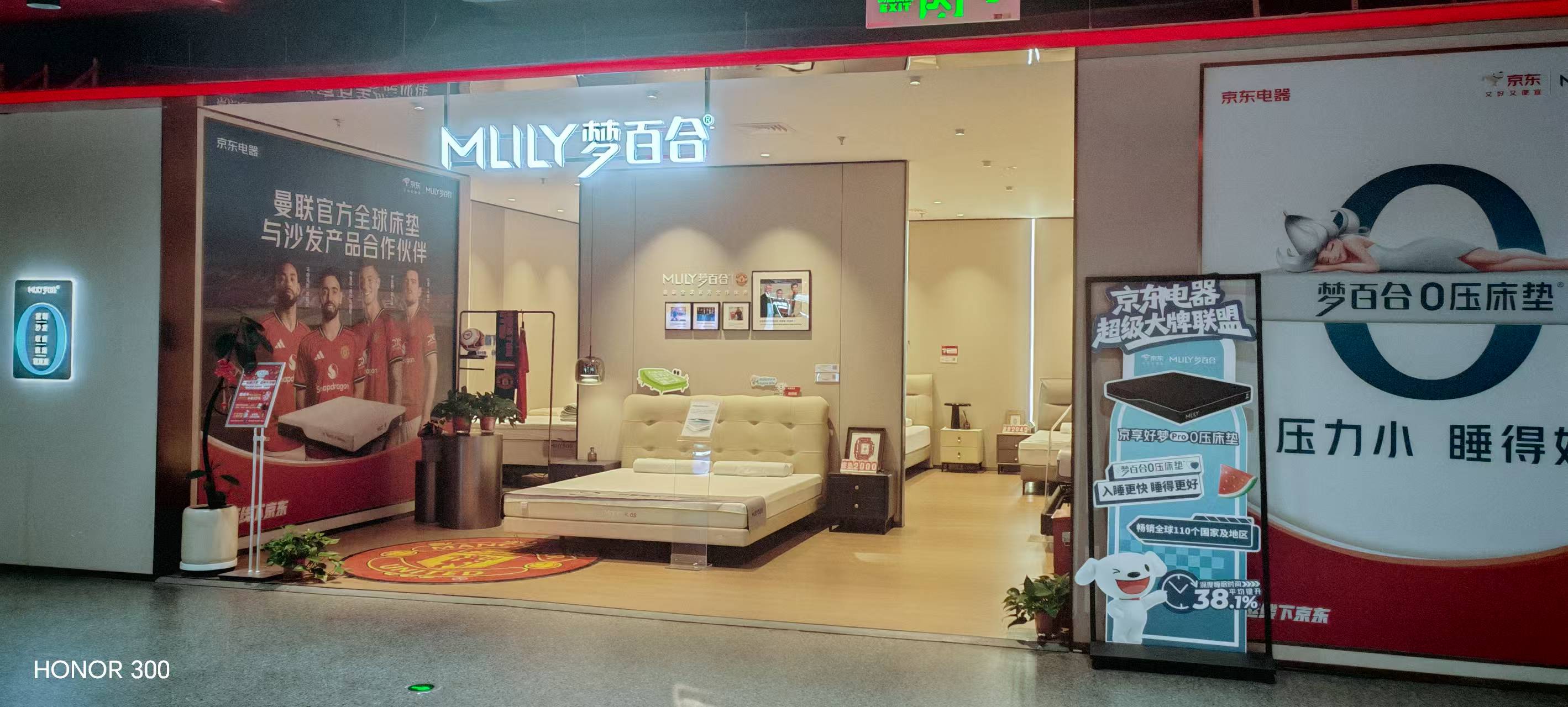 京东城旗店入口外景全景，门头两侧为品牌海报与易拉宝